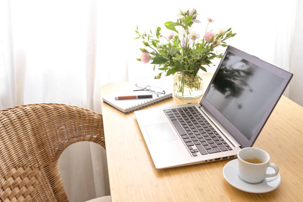laptop on table with flowers and coffee